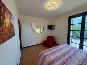 a bedroom with a bed and a red chair at Ami Affittacamere 3 in Castel San Giovanni