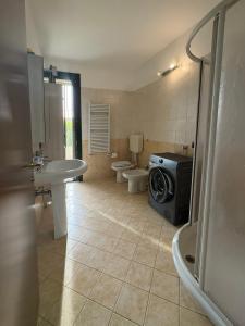 a bathroom with a washing machine in the middle of it at Ami Affittacamere 3 in Castel San Giovanni +12 photos