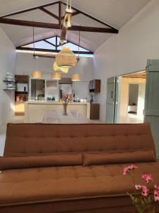 a living room with a couch and a kitchen at Casa Vento e Mar in Japaratinga