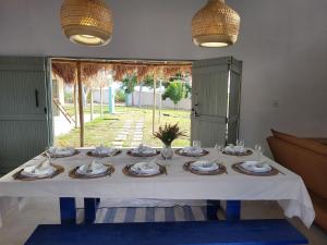 a table with plates and glasses on top of it at Casa Vento e Mar in Japaratinga +27 photos