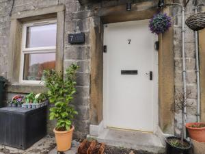 a white door on the side of a building with plants at Willow Wood in Settle