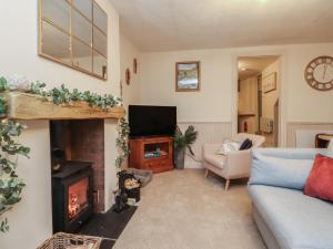 a living room with a couch and a fireplace at Willow Wood in Settle