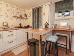 a kitchen with a table and two stools at Willow Wood in Settle