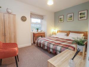 a bedroom with a bed and a chair and a table at Willow Wood in Settle