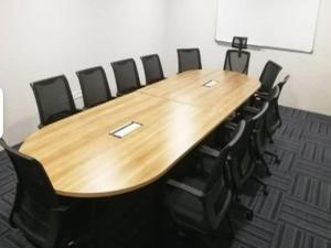a conference room with a wooden table and black chairs at Hotel Seri Warisan Melaka in Malacca