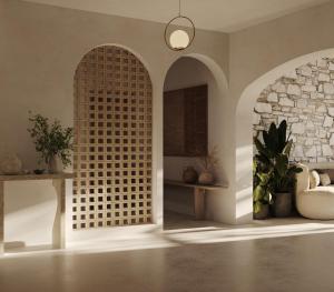 a room with two arched entryways with a stone wall at Byblos Mare-The Exclusive Beach Front Villa in Skala Sotiros