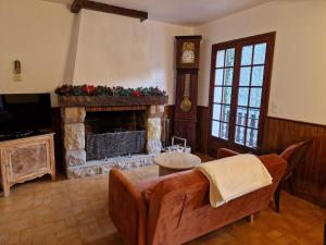 a living room with a couch and a fireplace at La Chênaie in Crespin