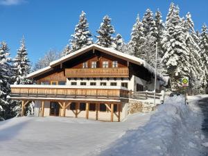 ein großes Holzhaus im Schnee mit Bäumen in der Unterkunft Sonneckalm in Berchtesgaden in Berchtesgaden
