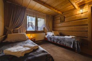 a bedroom with two beds and a window at Skowyrowe Wzgórze - Pokoje z pięknym widokiem na góry in Gliczarów