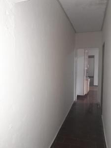 an empty room with a white wall and a hallway at Casa agrishow in Ribeirão Preto