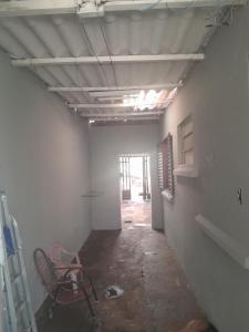 an empty hallway with a room with a ladder and a chair at Casa agrishow in Ribeirão Preto +5 photos