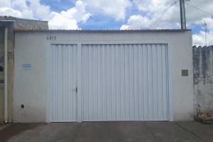 a white garage door on a white building at Casa agrishow in Ribeirão Preto