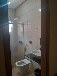 a bathroom with a toilet and a sink at Casa agrishow in Ribeirão Preto