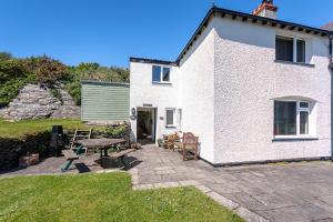 a white house with a picnic table and a patio at 3 Bed in Aberdyfi oc-dy024 in Aberdyfi