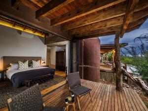 a bedroom with a bed on a wooden deck at Madikwe Safari Lodge in Madikwe Game Reserve