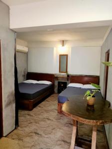 a room with two beds and a table in it at Yala Mila Villa in Gangawelana
