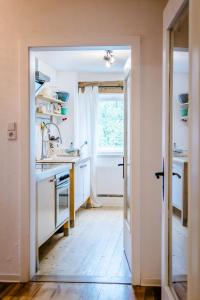a kitchen with white counters and a window at Seenswert - ein Wohlfühlort, in dem ALLE herzlich willkommen sind in Pähl +79 photos