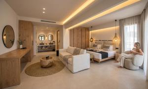 a woman is sitting in a hotel room at Indigo Suites Collection Adults Only in Hersonissos +61 photos