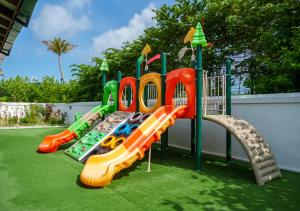 a playground with three slides on the grass at Joy Island Maldives All Inclusive Resort in Male City