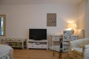 a living room with a tv and a couch and a table at Christian Gartenhotel in Nieder-Olm