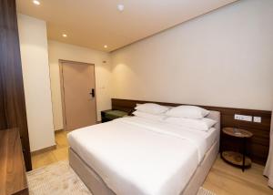 a bedroom with a large bed with white sheets and pillows at 7EVEN Suites in Lagos
