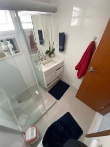 a bathroom with a shower and a sink and a mirror at Quarto próx a Praia do Morro in Guarapari +6 photos