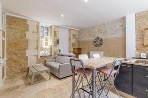 a kitchen and living room with a table and chairs at Cour des Moines - centre ville in Le Blanc