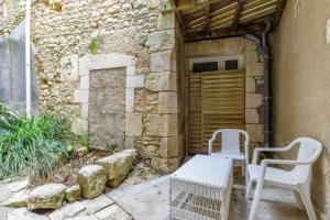 two chairs and a bench in front of a building at Cour des Moines - centre ville in Le Blanc
