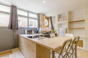 a kitchen with a wooden counter top and a table at Cour des Moines - centre ville in Le Blanc +7 photos