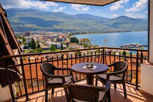 a balcony with a table and chairs and a view of the water at Villa Mesokastro in Ohrid +41 photos