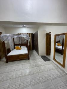 a room with two bunk beds and a mirror at Mtwapa- North Coast in Mtwapa