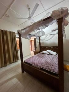 a bedroom with a canopy bed with a ceiling at Mtwapa- North Coast in Mtwapa