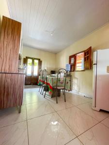 a kitchen with a table and chairs and a refrigerator at Casarão Vale das Hortênsias in Bonito