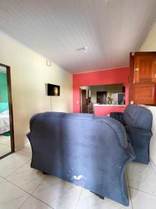 a living room with a blue couch and a kitchen at Casarão Vale das Hortênsias in Bonito +10 photos
