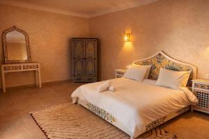 a bedroom with a large bed and a mirror at Dar Laydam in Aït Zat