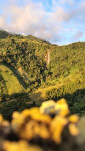 a view of a hill with a waterfall in the distance at Vista cascada lodge in San Isidro de El General