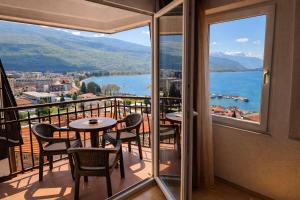 a balcony with tables and chairs and a view of the water at Villa Mesokastro in Ohrid