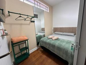 a small bedroom with a bed and a mirror at Pousada Monte Gerizim in São Paulo
