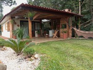 a house with a wooden porch with a hammock at Cantinho do Sossego in Prudentópolis
