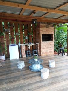 a patio with a table and stools and a fireplace at Cantinho do Sossego in Prudentópolis