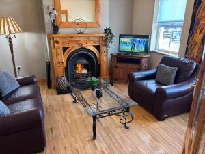 a living room with two couches and a fireplace at Albert Lock Bungalow 5 minute drive from Carrick in Carrick on Shannon