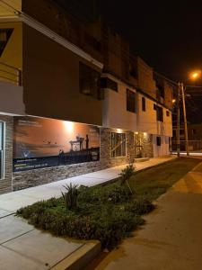 a building with a sign on the side of it at night at "HOSTAL LA NOCHE" -Pisco in Pisco