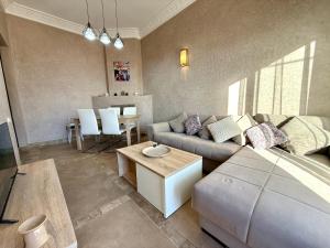 a living room with a couch and a table at Beach Mama Waky Marrakech Appartement Premium Piscine & Vue Atlas in Marrakesh