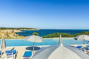a swimming pool with chairs and umbrellas and a swimming pool at Camping l'Arquet - Mobil-home Premium 4 pièces 6 personnes climatisé MAE-3771 in Martigues