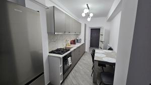 a kitchen with a stove and a table in it at NORDIC Residence Apart Hotel in Suceava