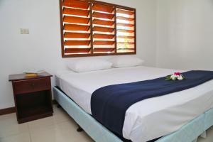 una camera da letto con un letto bianco con una finestra di Bua Bed & Breakfast a Nadi