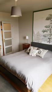 a large bed in a bedroom with a large painting on the wall at chambres d'hôtes du Tilleul in Nanteuil-en-Vallée