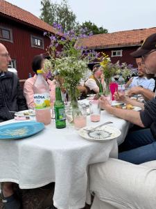 een groep mensen die rond een tafel zitten met drankjes bij Muntergården i Nusnäs in Nusnäs