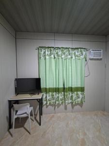 a room with a desk and a green curtain at Nancy's Place in Caniton