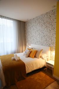 a bedroom with a large bed and a window at Apartamento Mimosa Diseño Exclusivo in Ponteareas